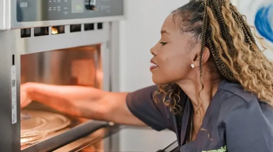 Team Member Cleaning Oven
